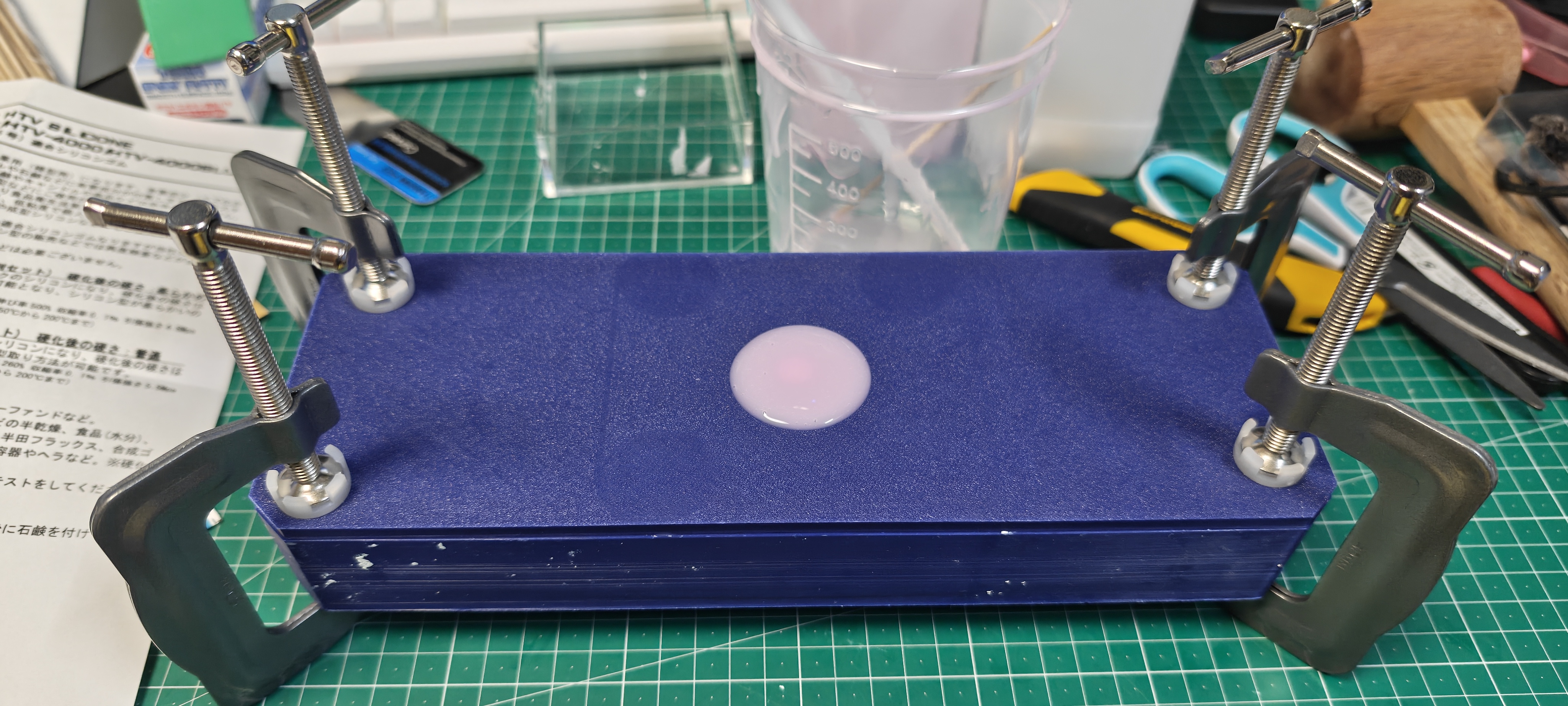 シリコンを流し込んでクランプで押さえつけている写真